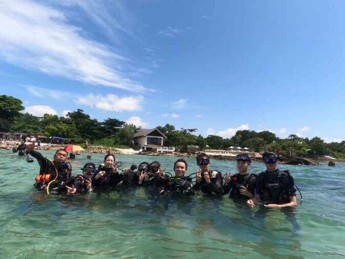 セブ島の海上に立つ成人男女8人のダイバーと浜辺